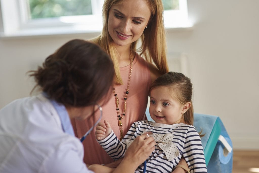 doctor evaluating child patient with their mother