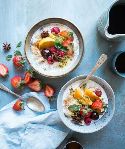 two smoothie oatmeal bowls with fresh fruit